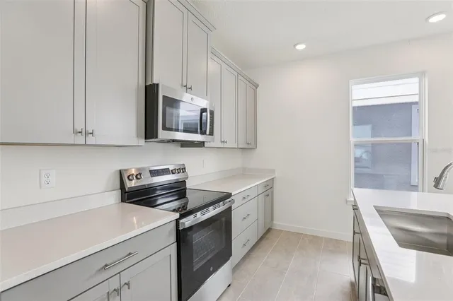 a kitchen with stainless steel appliances granite countertop a sink and a stove