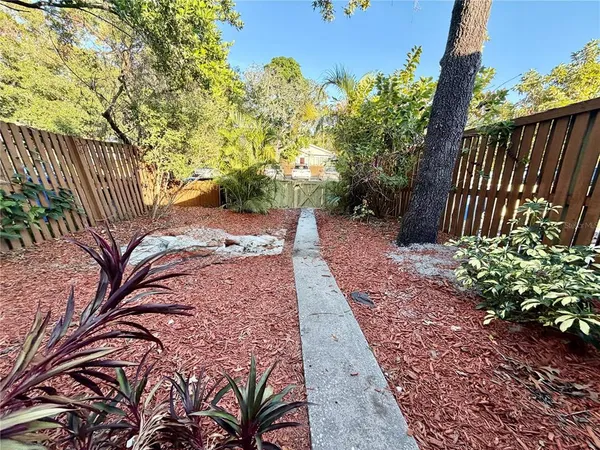a view of a backyard with potted plants and wooden fence