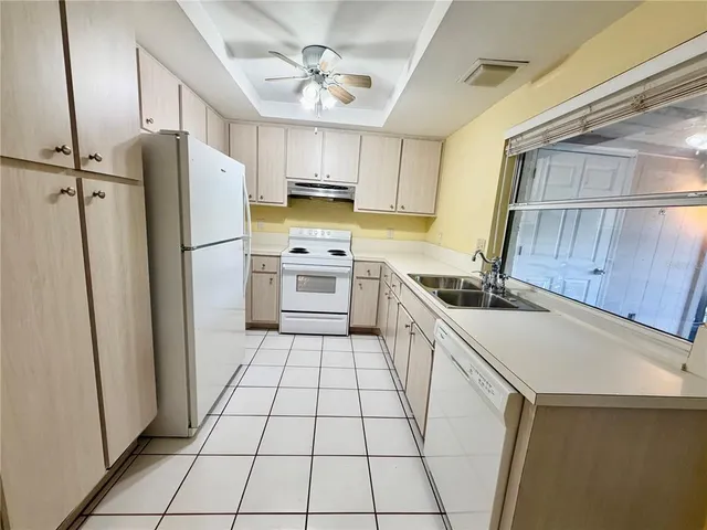 a kitchen with a refrigerator a sink and cabinets