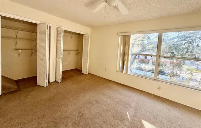 an empty room with a fireplace and windows