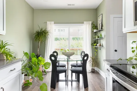 a dining room with furniture potted plants and wooden floor