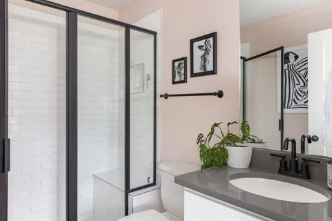 a bathroom with a granite countertop sink a mirror and shower