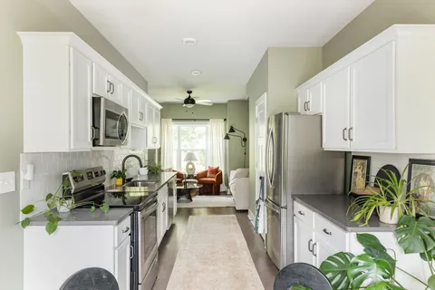 a kitchen with stainless steel appliances a refrigerator a sink a stove a microwave a refrigerator and cabinets