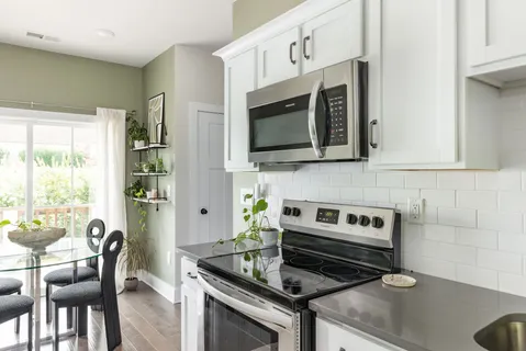 a kitchen with stainless steel appliances white cabinets and a stove top oven