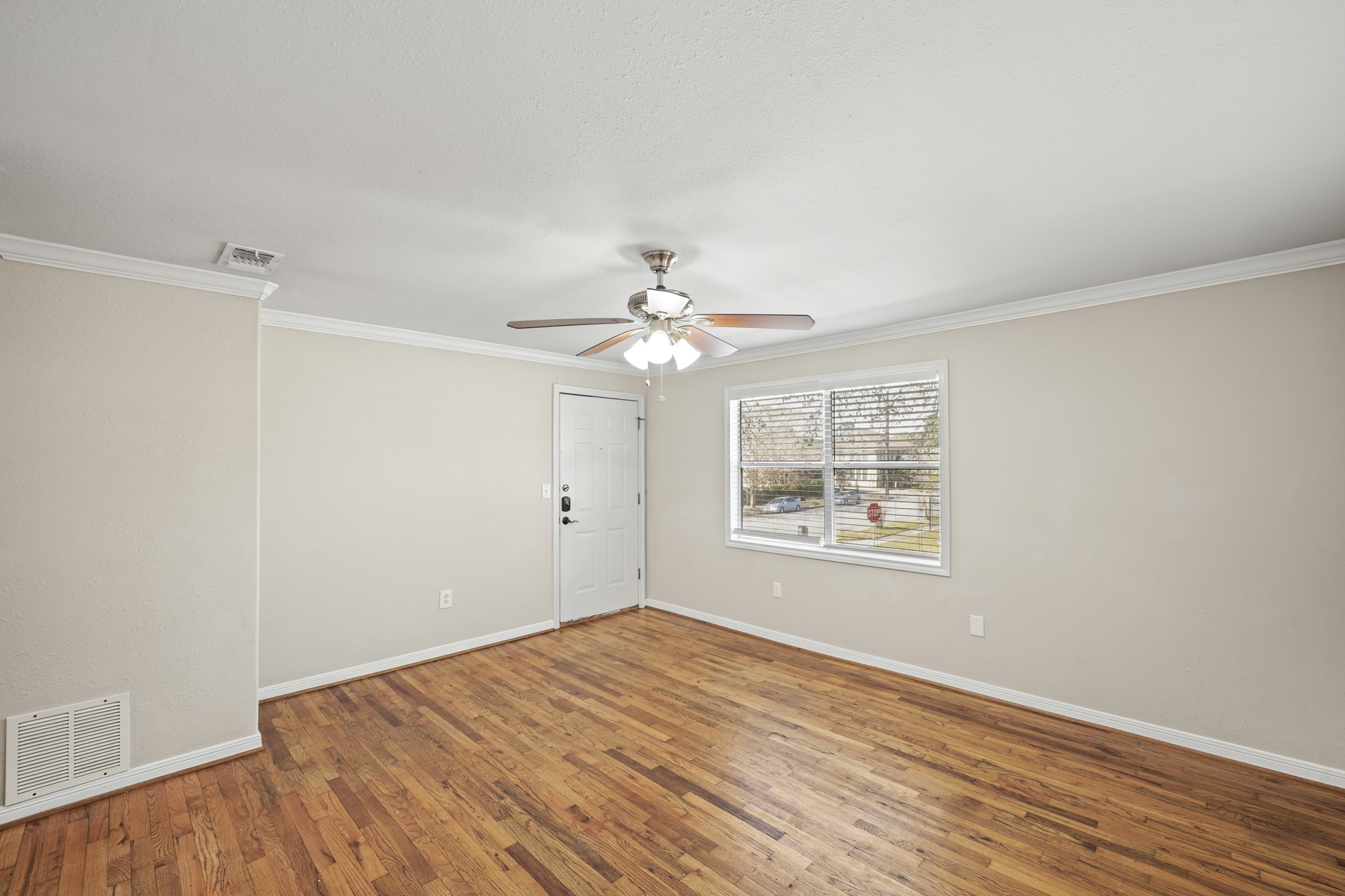 1539 Hawthorne Street, Unit 3 Houston, TX 77006 - Photo 4 of 11 wooden floor in an empty room with a window