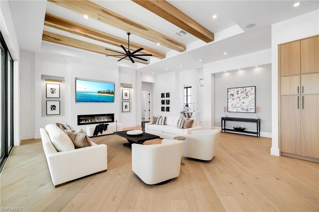 15850 Hampton View Fort Myers, FL 33908 - Photo 12 of 38 Living area featuring beamed ceiling, a glass covered fireplace, light wood-type flooring, recessed lighting, and ceiling fan