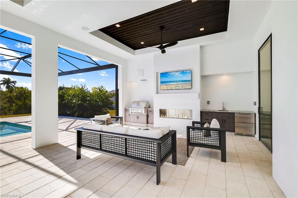 15850 Hampton View Fort Myers, FL 33908 - Photo 34 of 38 View of patio featuring an outdoor kitchen and area to lounge, a sunroom, a ceiling fan, a lanai, and an outdoor pool