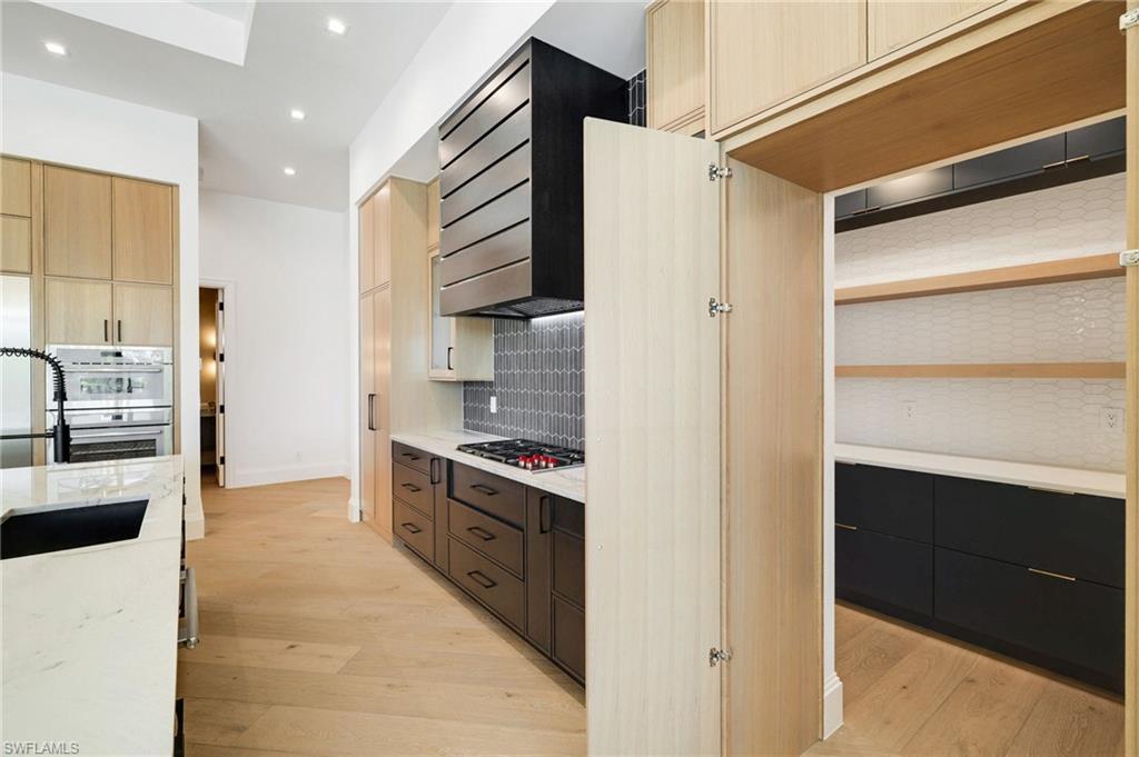 15850 Hampton View Fort Myers, FL 33908 - Photo 6 of 38 Kitchen with light wood finished floors, two tone color scheme, light stone countertops, modern cabinets, and stainless steel appliances