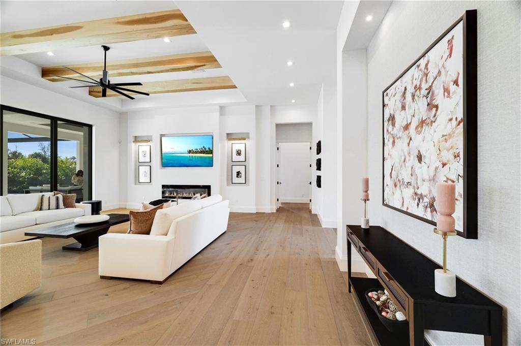 15850 Hampton View Fort Myers, FL 33908 - Photo 10 of 38 Living area featuring light wood-style floors, a glass covered fireplace, a ceiling fan, recessed lighting, and beam ceiling