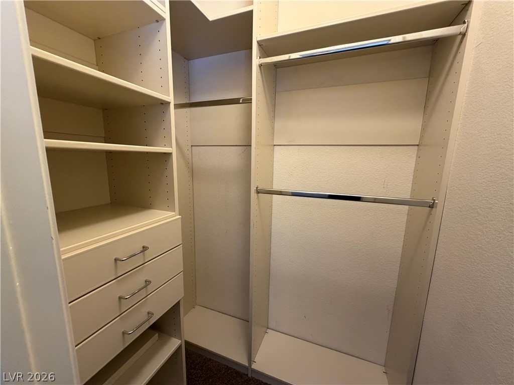7613 Roop Street Las Vegas, NV 89131 - Photo 16 of 25 Custom built-in shelving and hanging rods maximize storage in this walk-in closet.
