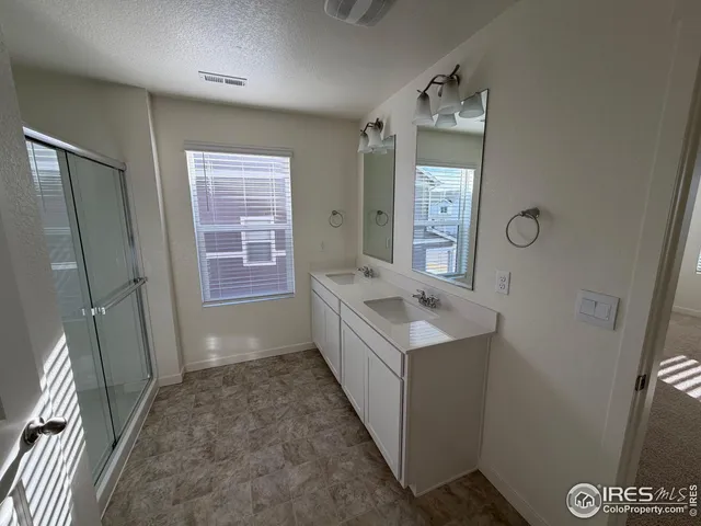 a bathroom with a double vanity sink a toilet and a shower