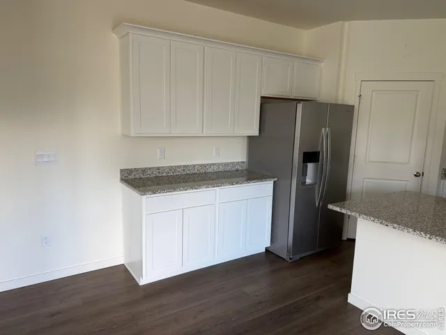 a kitchen with a refrigerator sink and cabinets