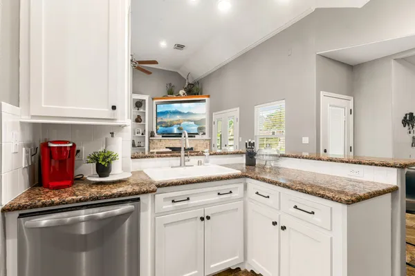 a kitchen with stainless steel appliances granite countertop a sink stove and cabinets