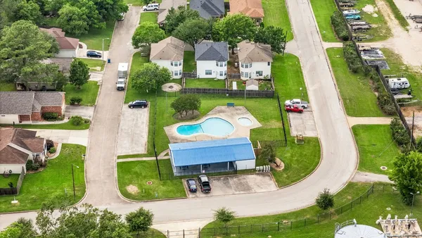 an aerial view of a house with a swimming pool a yard and outdoor seating