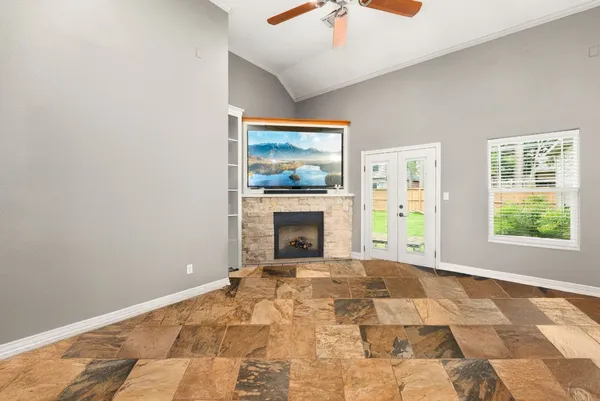 a view of an empty room with window and fire place