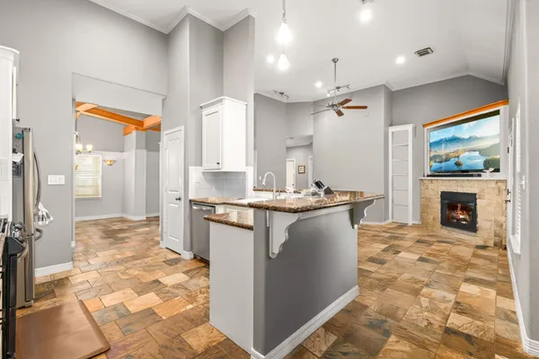 a kitchen with kitchen island granite countertop a stove a sink and a refrigerator