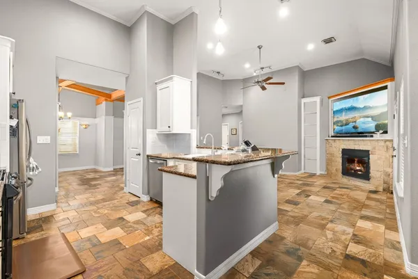 a kitchen with kitchen island granite countertop a stove a sink and a refrigerator
