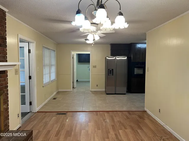 a view of a livingroom with a fireplace a chandelier and wooden floor