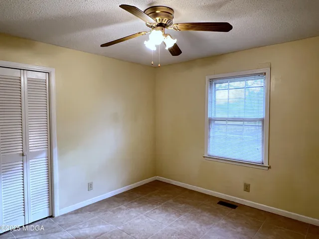 an empty room with a ceiling fan and fan