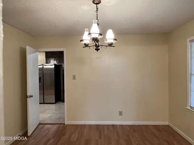 a view of a room with wooden floor closet and windows
