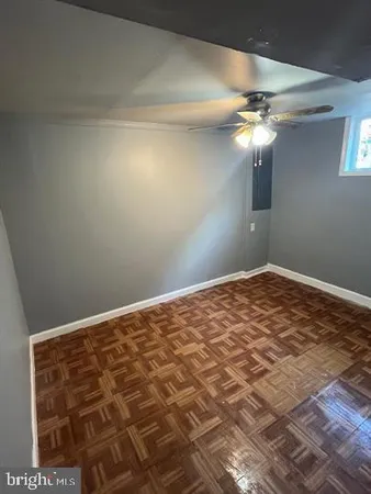 a view of a big room with wooden floor and chandelier fan