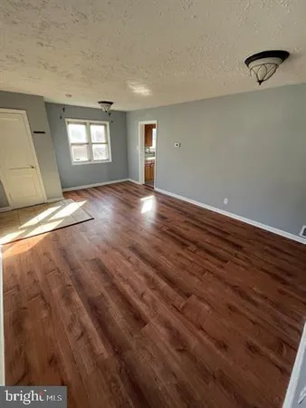 a view of empty room with window and wooden floor