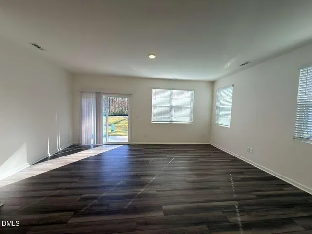 a view of a kitchen with kitchen island wooden floor appliances and cabinets