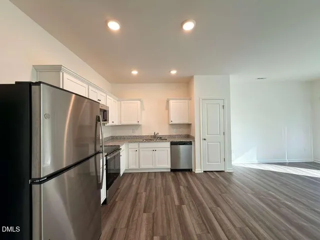 a kitchen with stainless steel appliances a refrigerator a sink a stove a microwave and cabinets