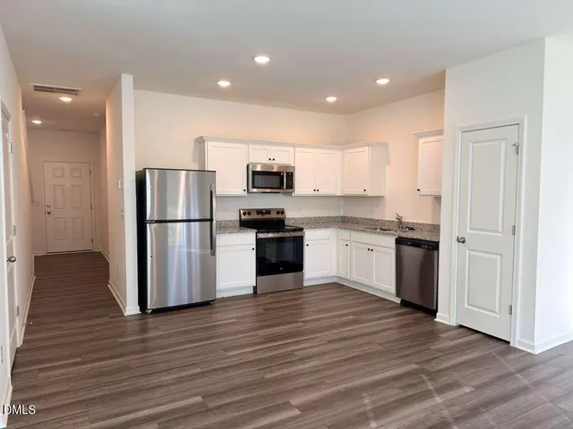 a kitchen with a refrigerator and a stove top oven