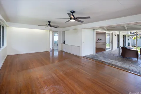 a view of a livingroom with wooden floor and ceiling fan