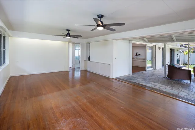 a view of a livingroom with wooden floor and ceiling fan