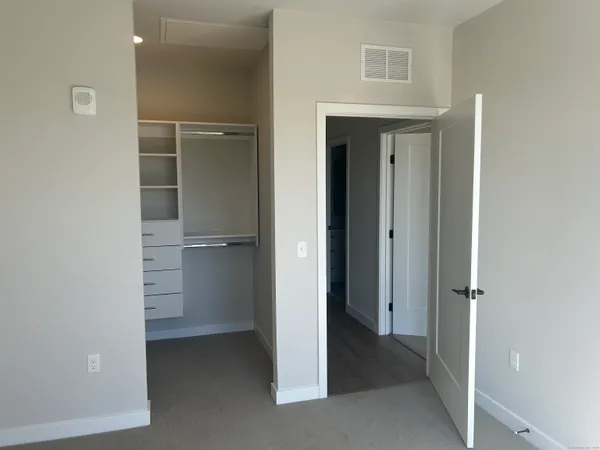 a view of a room with a walk in closet and wooden floor