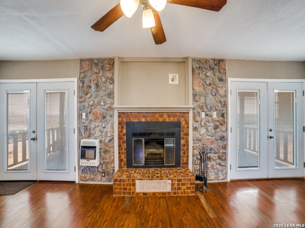 6953 Von Ormy Road Von Ormy, TX 78073 - Photo 13 of 28 a living room with wooden floors and a fireplace