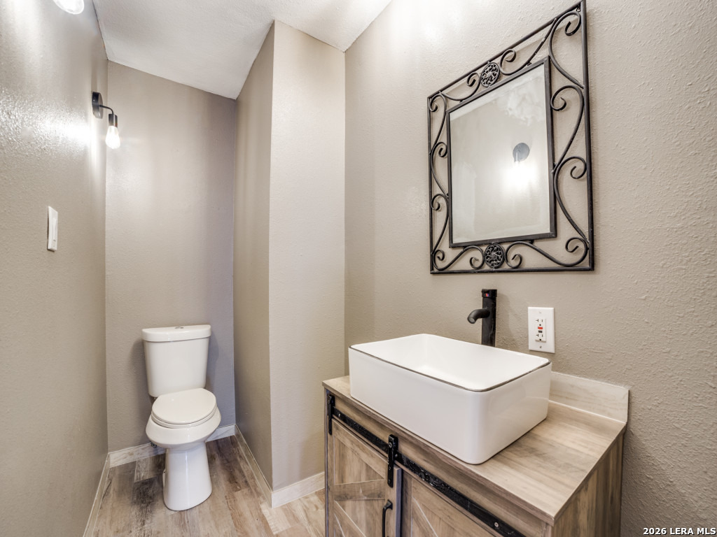 6953 Von Ormy Road Von Ormy, TX 78073 - Photo 15 of 28 a bathroom with a toilet sink and mirror