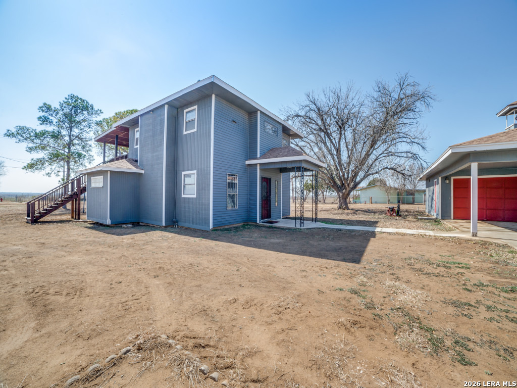 6953 Von Ormy Road Von Ormy, TX 78073 - Photo 24 of 28 a front view of a house with a yard and garage