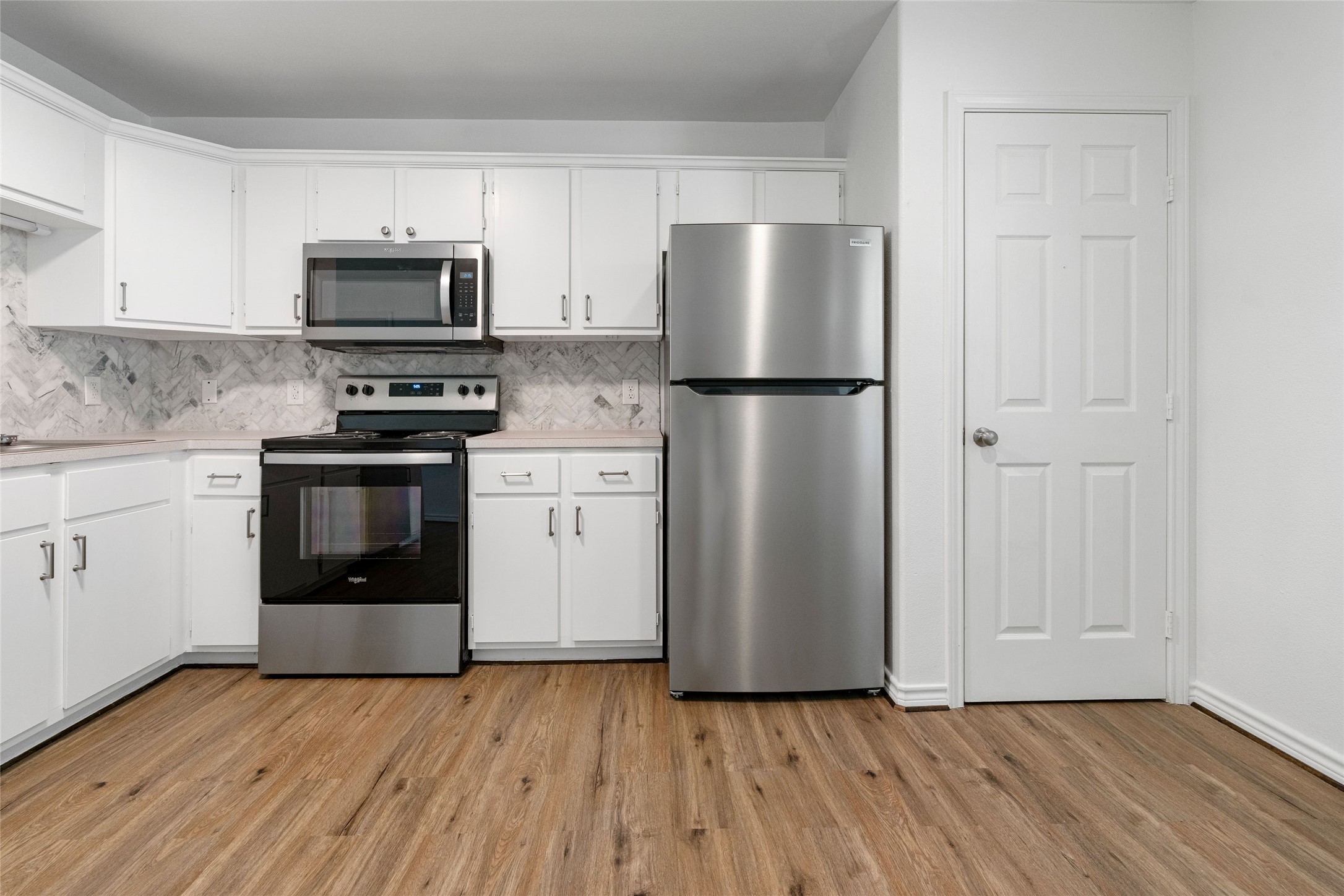 210 Brazos Street, Unit 102 Brazoria, TX 77422 - Photo 3 of 20 a kitchen with wooden cabinets and stainless steel appliances