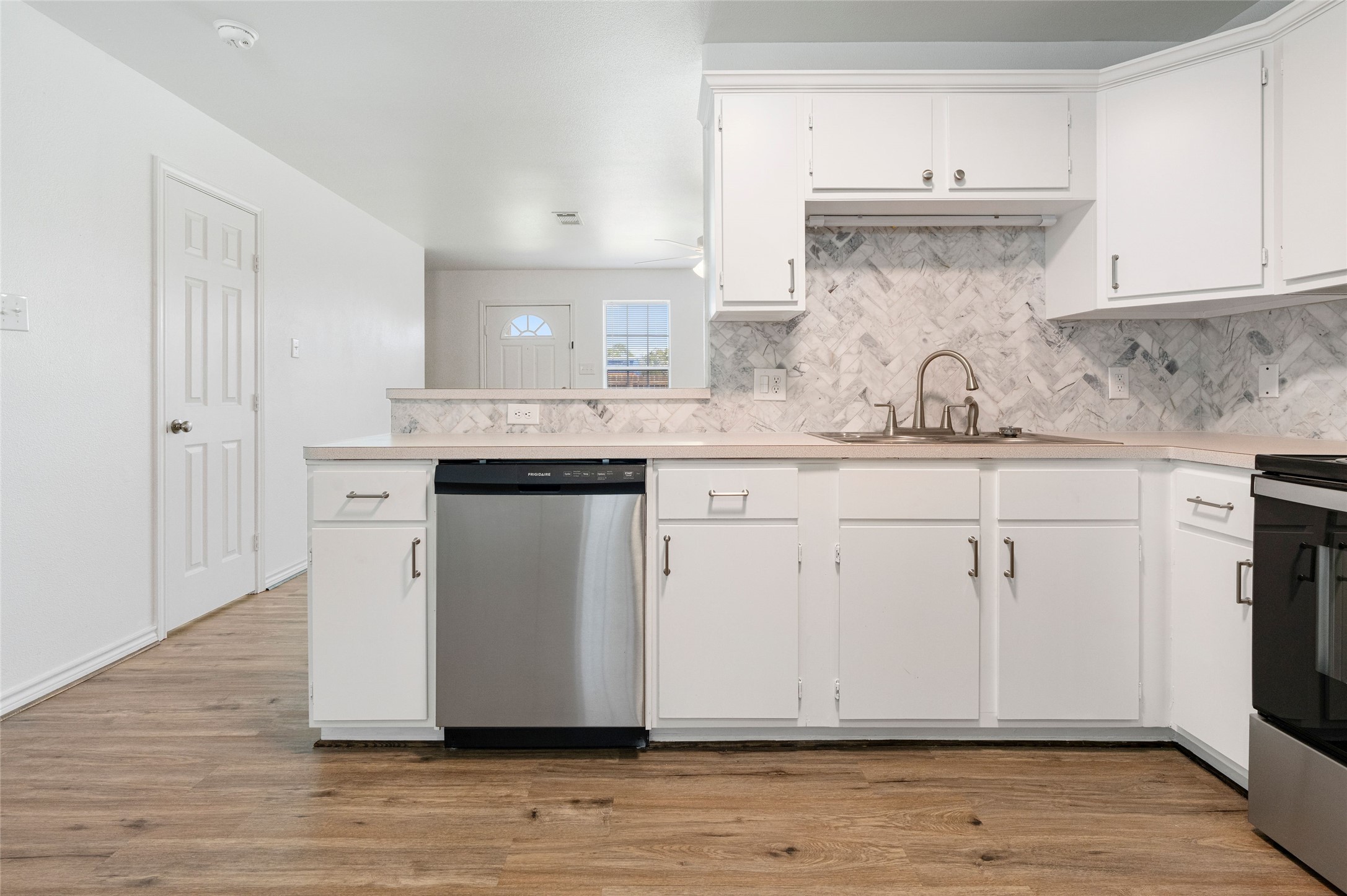 210 Brazos Street, Unit 102 Brazoria, TX 77422 - Photo 4 of 20 a kitchen with stainless steel appliances granite countertop a sink and cabinets with wooden floor