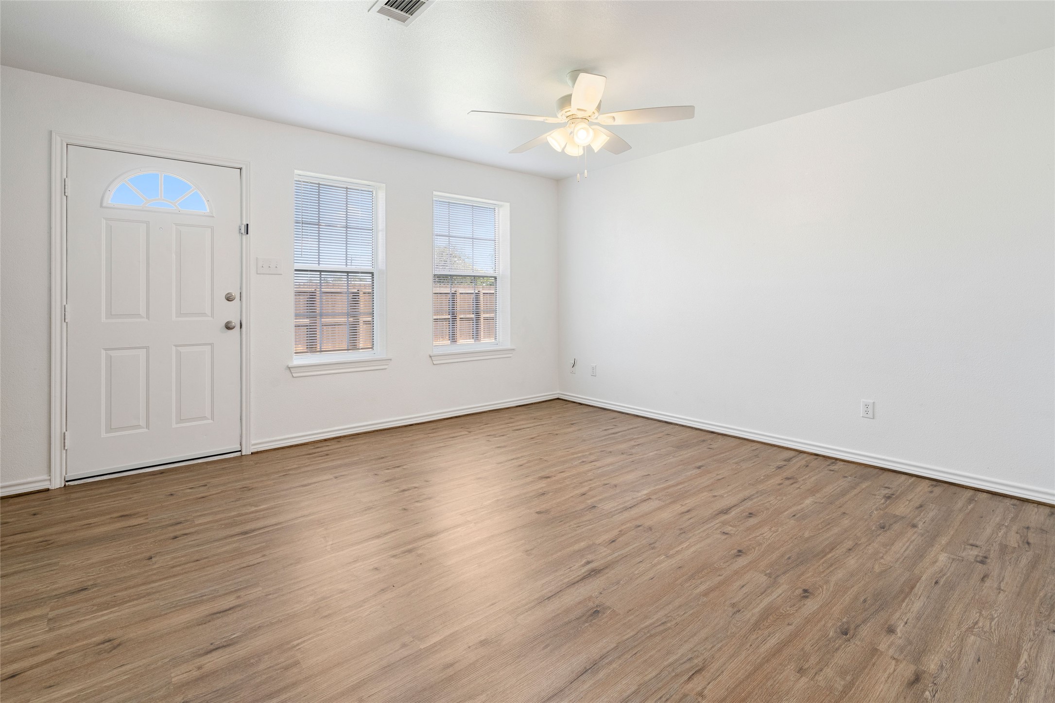 210 Brazos Street, Unit 102 Brazoria, TX 77422 - Photo 8 of 20 wooden floor in an empty room with a window