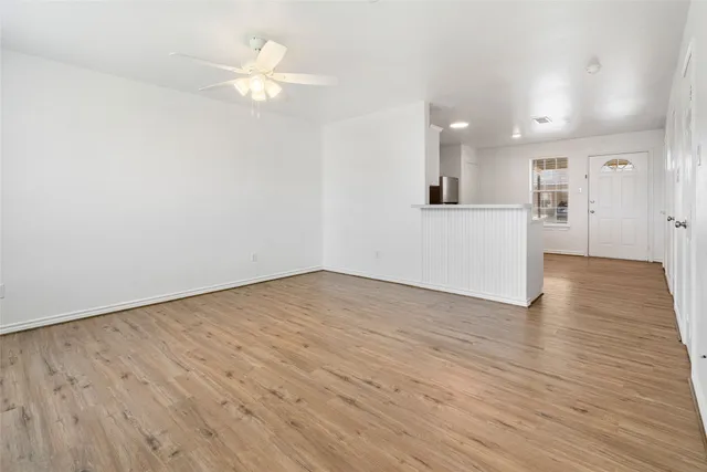 a view of a livingroom with a ceiling fan & wooden floor
