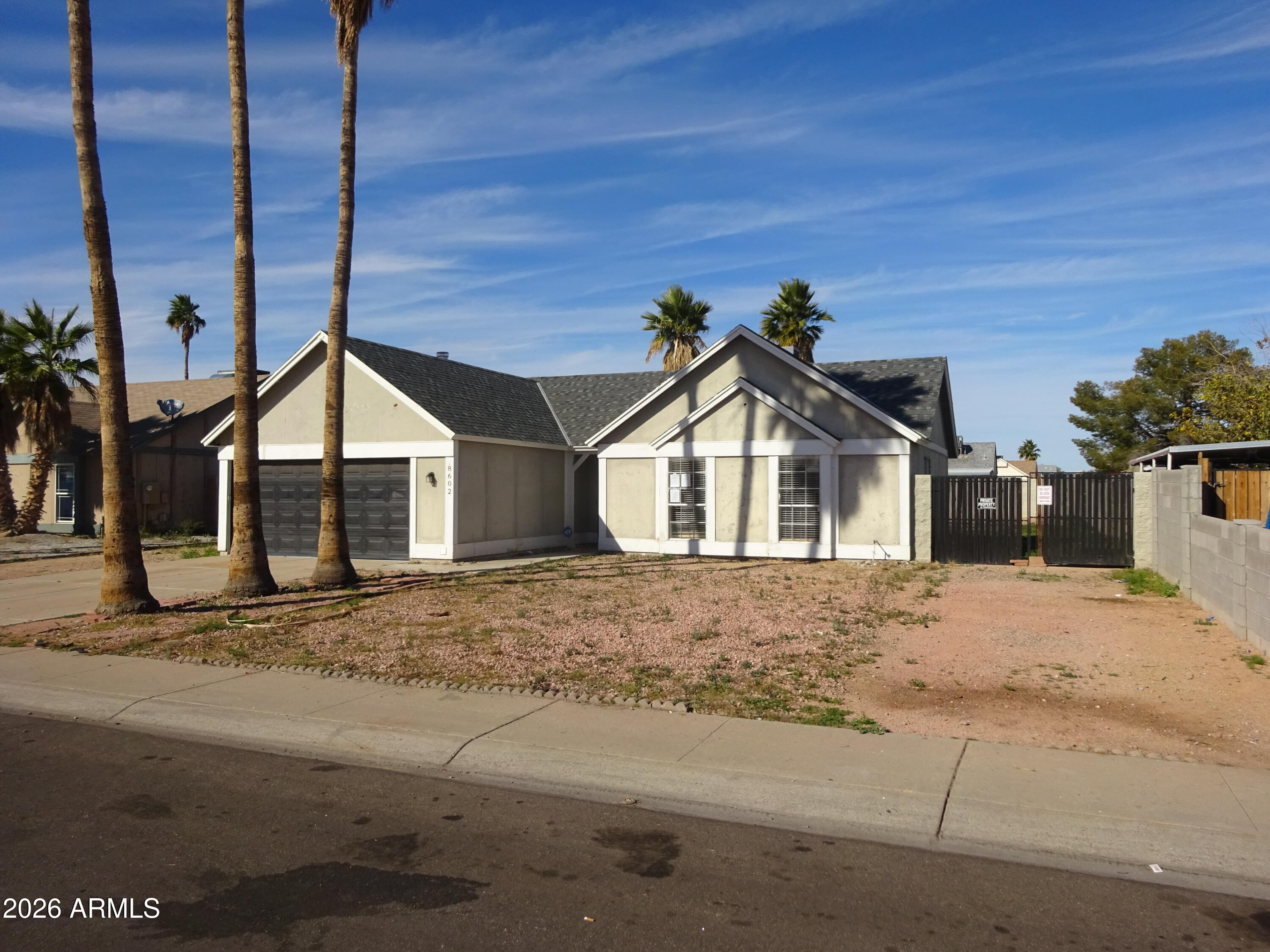 8602 West Wethersfield Road Peoria, AZ 85381 - Photo 5 of 26 a view of a house next to a road and yard