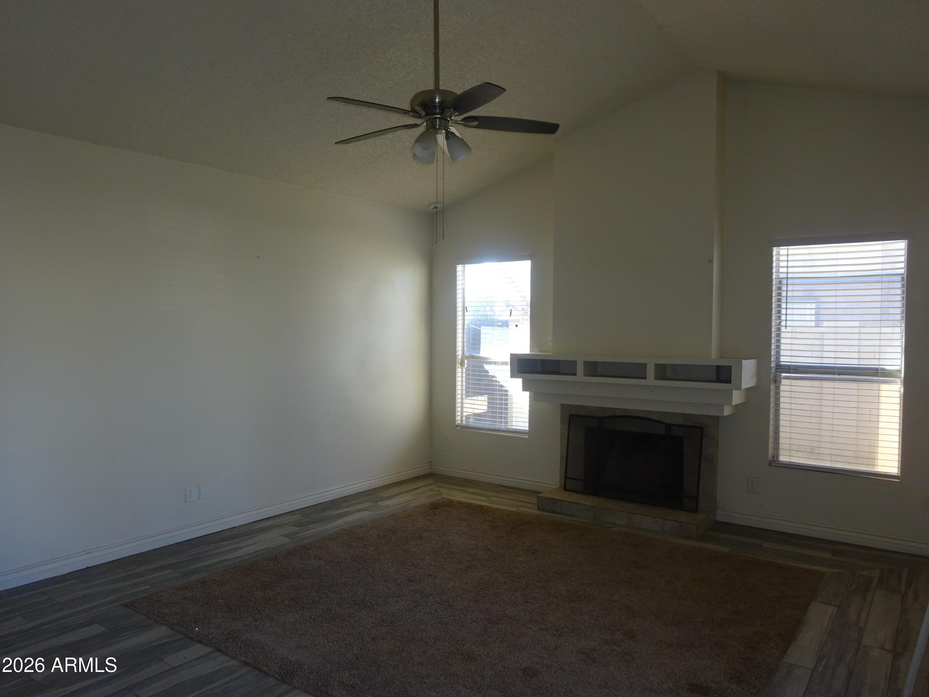 8602 West Wethersfield Road Peoria, AZ 85381 - Photo 10 of 26 an empty room with a fireplace and windows