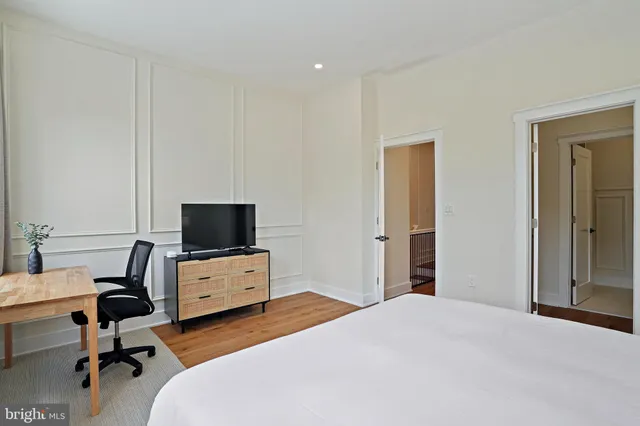 a spacious bedroom with a bed and a rug