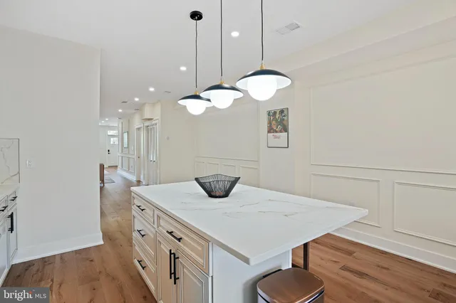 a kitchen with stainless steel appliances a stove a sink a cabinets and wooden floor