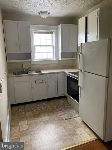 a kitchen with stainless steel appliances granite countertop a sink a stove a refrigerator a microwave and cabinets