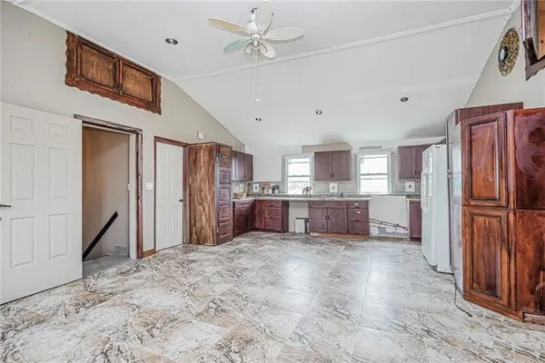 a large kitchen with granite countertop a refrigerator and a stove top oven