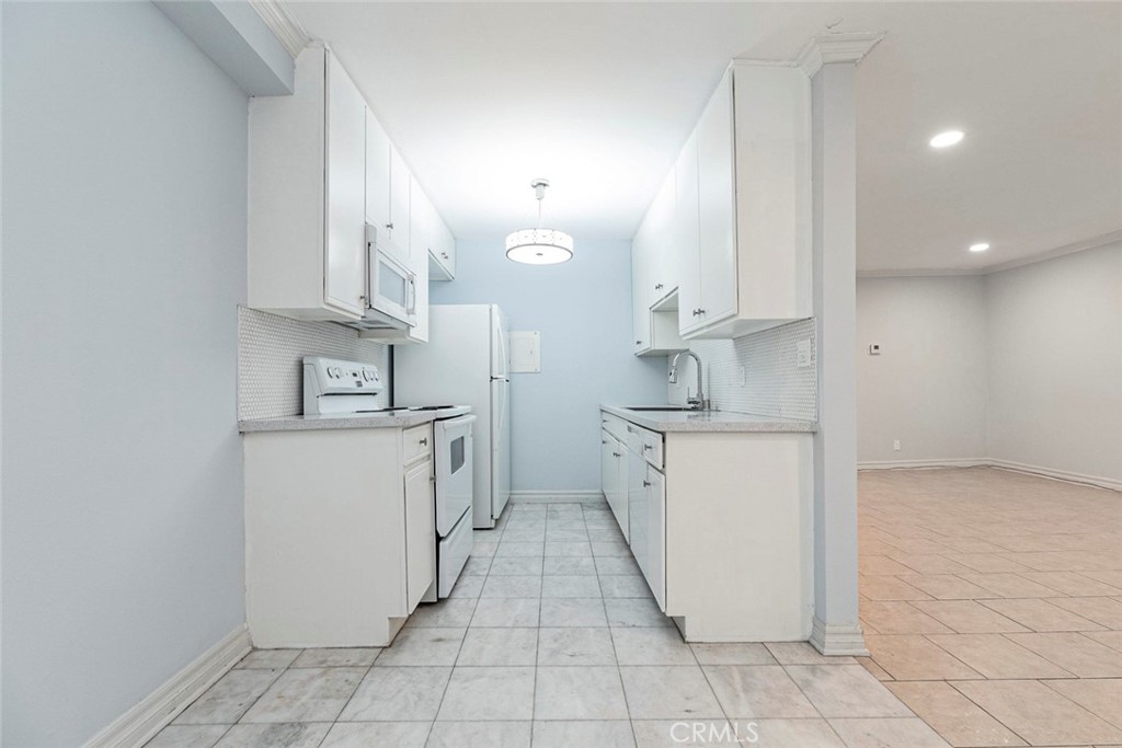 121 Sinclair Avenue, Unit 122 Glendale, CA 91206 - Photo 5 of 23 a kitchen with white cabinets and white appliances
