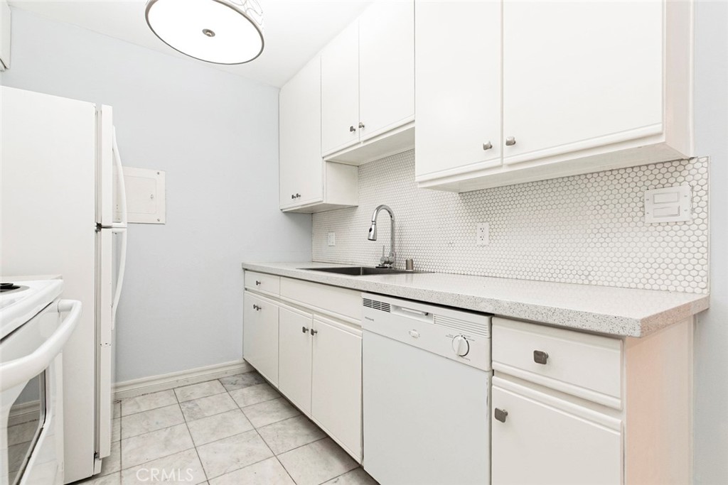 121 Sinclair Avenue, Unit 122 Glendale, CA 91206 - Photo 7 of 23 a kitchen with granite countertop white cabinets and a sink