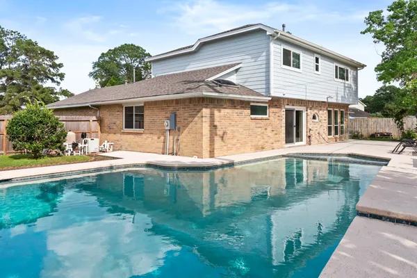 a front view of a house with swimming pool having outdoor seating