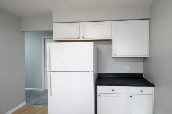 a kitchen with a refrigerator and cabinets