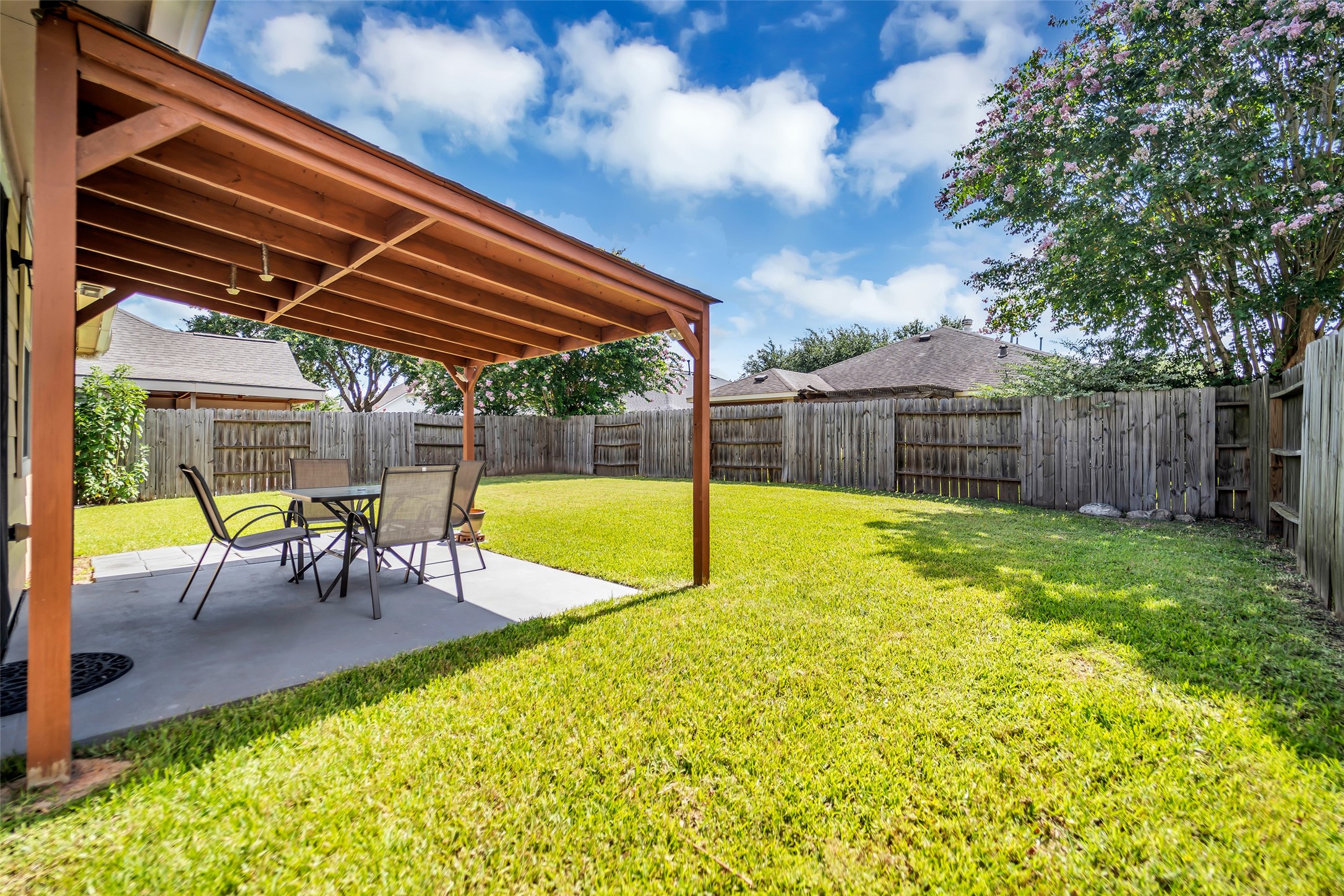 5406 Quarry Ridge Road Richmond, TX 77407 - Photo 32 of 36 Covered back patio overlooking a spacious, fully fenced backyard with plenty of room for outdoor dining, entertaining, pets, play, or gardening. The covered patio provides a comfortable shaded retreat while the expansive lawn offers flexible outdoor living space.